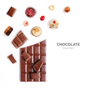Creative layout made of chocolate bar and chocolate praline on the white. Flat lay. Food concept. Macro  concept.
