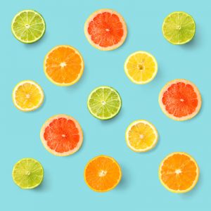 Creative layout made of lemon, lime, orange and grapefruit. Flat lay. Food concept. Lemon, lime, orange and grapefruit on turquoise background.