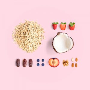 Creative layout made of oatmeal, coconut, strawberry, plum, dried dates, blueberry, almond and walnut. Flat lay. Food concept.
