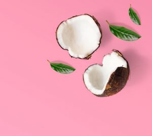 Creative layout made of coconuts and leaves. Flat lay. Food concept. Coconut on pink background.