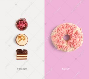 Creative layout made of pink donut and chocolate pralines. Flat lay. Food concept. Macro  concept.