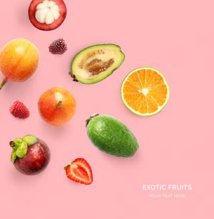 Creative layout made of orange, strawberry, sweet granadilla, mangosteen, blackberry and feijoa. Flat lay. Food concept. Tropical fruits on the yellow background.