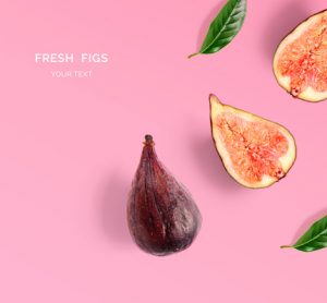 Creative layout made of figs and leaves. Flat lay. Food concept. Figs on pink background.