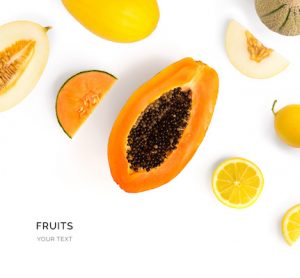 Creative layout made of fruits. Flat lay. Food concept. Papaya, lemon, melon on white background.