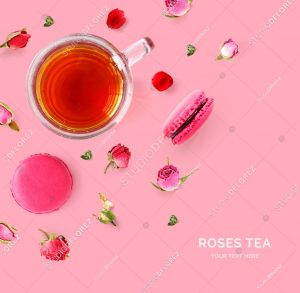 Creative layout made of cup of tea,roses and macaroons on pink background.Flat lay. Food concept.
