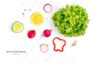 Creative layout made of red pepper, cucumber, radish, lemon, garlic and lettuce. Flat lay. Food concept. Vegetables isolated on white background.