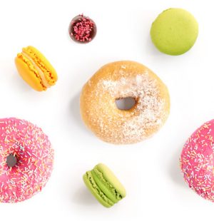 Seamless pattern made of macaroons and donut on the white background. Flat lay. Food concept.