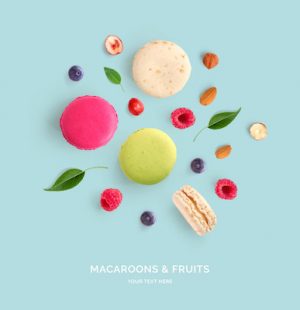 Creative layout made of macaroons, raspberry, blueberry and nuts . Flat lay. Food concept. Abstract background.