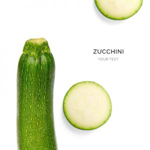 Creative layout made of green zucchini on the white background. Flat lay. Macro concept.