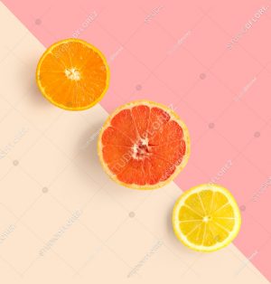 Creative layout made of grapefruit, orange, lemon. Flat lay. Food concept. Grapefruit, orange, lemon on pink and beige background.