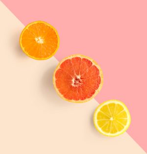 Creative layout made of grapefruit, orange, lemon. Flat lay. Food concept. Grapefruit, orange, lemon on pink and beige background.