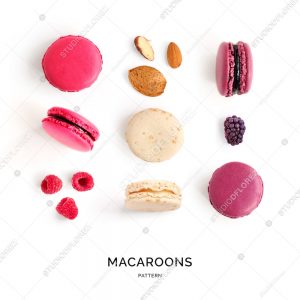 Seamless pattern made of colorful macaroons, raspberry, almont on the white background. Flat lay. Food concept.