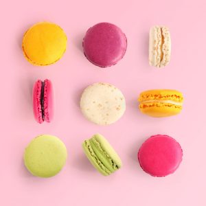Creative layout made of colorful macaroons on the pink background. Flat lay. Food concept.