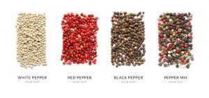 Creative layout made of pepper mix, black pepper, white pepper and red pepper isolated on white background. Flat lay. Food concept.