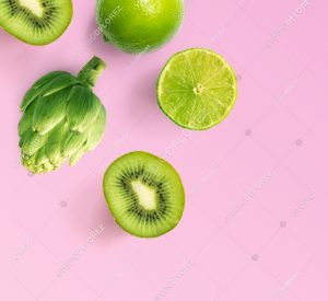 Creative layout made of lime, kiwi and artichoke. Flat lay. Food concept. Lime, kiwi and artichoke on purple background.