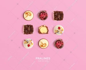 Creative layout made of pralines on pink background. Flat lay. Food concept. Macro  concept.