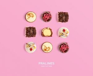 Creative layout made of pralines on pink background. Flat lay. Food concept. Macro  concept.