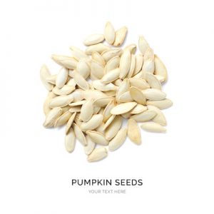 Creative layout made of pumpkin seeds on the white background. Flat lay. Food concept. Macro  concept.