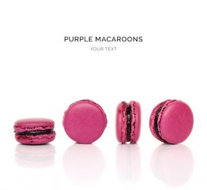 Creative layout made of purple macaroons on the white background. Flat lay. Food concept.