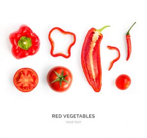 Creative layout made of red pepper, tomato and chilli pepper. Flat lay. Food concept. Red vegetables isolated on white background.