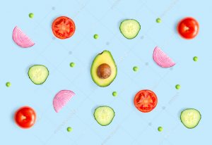 Creative layout made of green peas, avocado, tomato, onion and cucumber on the blue background.. Flat lay. Food concept.