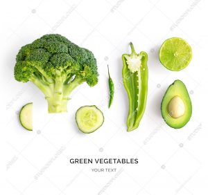 Creative layout made of avocado, lime, broccoli, green pepper, cucumber, chilli pepper and zucchini. Flat lay. Food concept. Green vegetables isolated on white background.