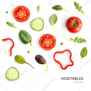 Creative layout made of tomato, cucumber and salad leaves on the white background. Flat lay. Food concept.